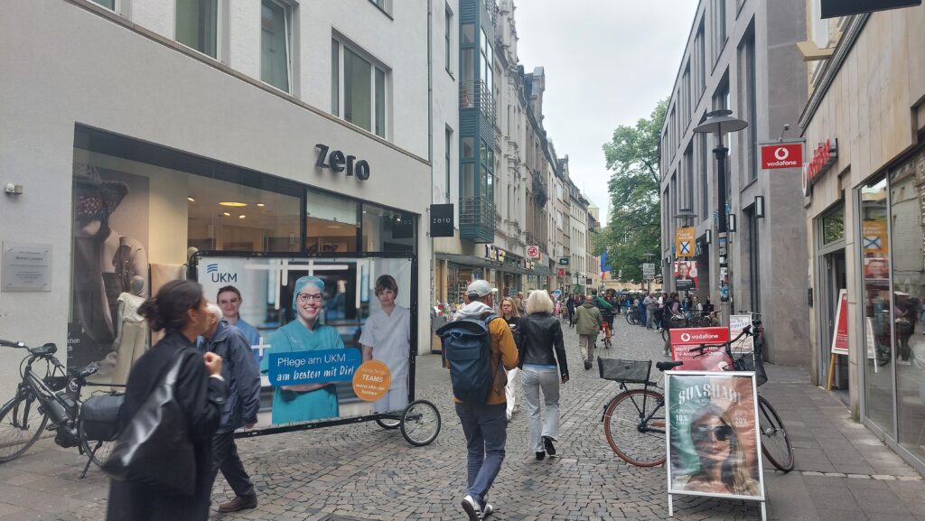 Im Stadtzentrum auf potenzielle Mitarbeiter treffen, mit der Fahrradwerbung von UKM in Münster